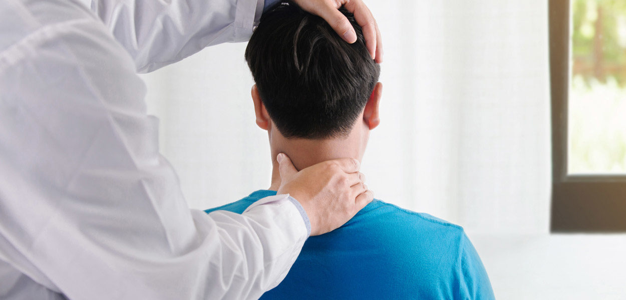Chiropractor-adjusting-male-patient’s-neck