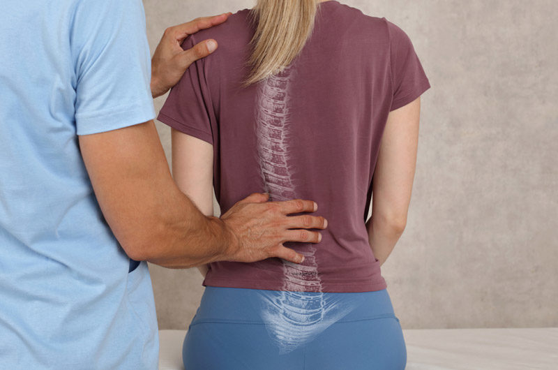 Chiropractor-evaluating-patient-with-low-back-pain-who-needs-spinal-decompression-therapy-(DRX)