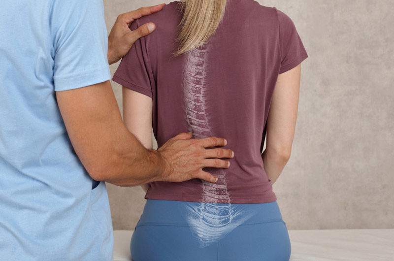 Chiropractor-touching-patient’s-back-with-scoliosis