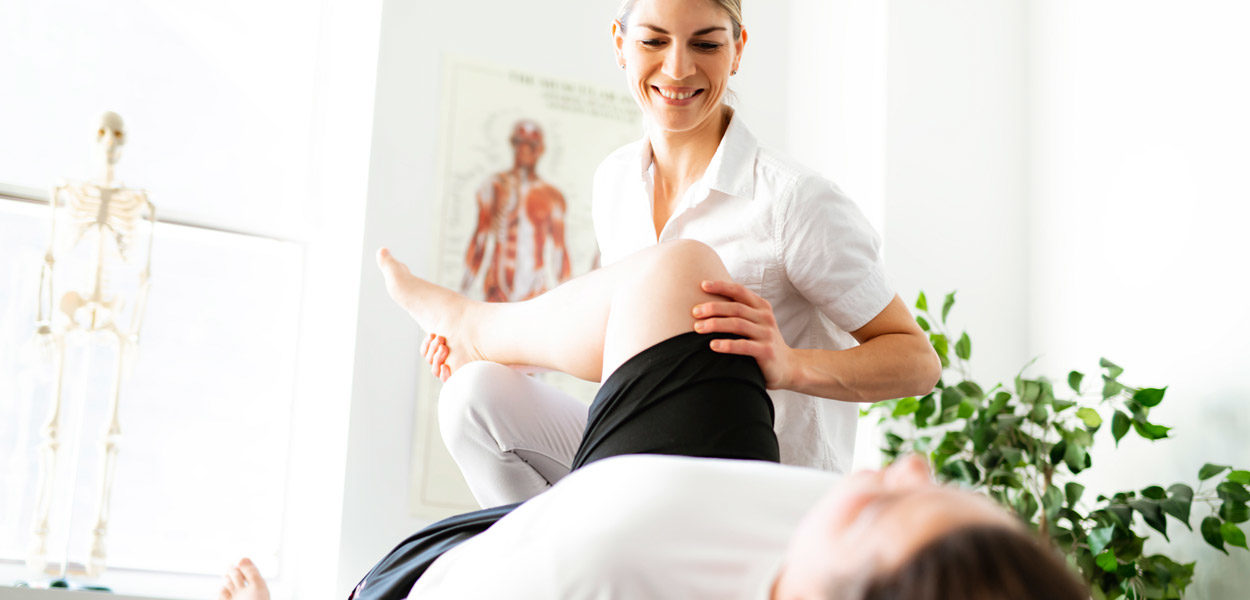 Female-physical-therapist-helping-a-patient-perform-therapeutic-exercises