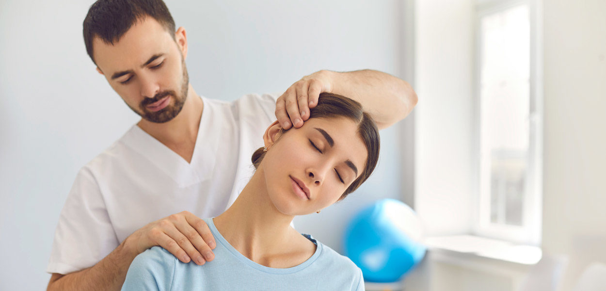Male-physical-therapist-evaluating-female-patient’s-neck-during-posture-assessment